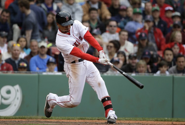 Boston's Mookie Betts hits a tiebreaking RBI triple in the seventh inning Sunday against Houston at Fenway Park.