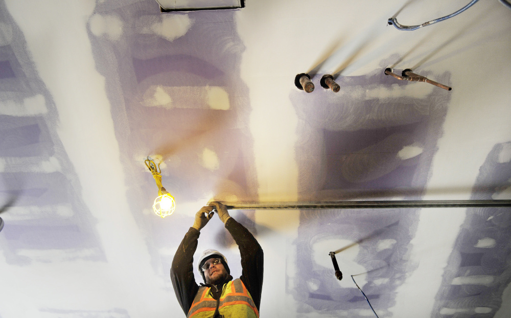Sy Kottmann of the mechanical contractor Johnson & Jordan prepares a room for a hot water tank Monday at the Downeaster layover station being built in Brunswick.