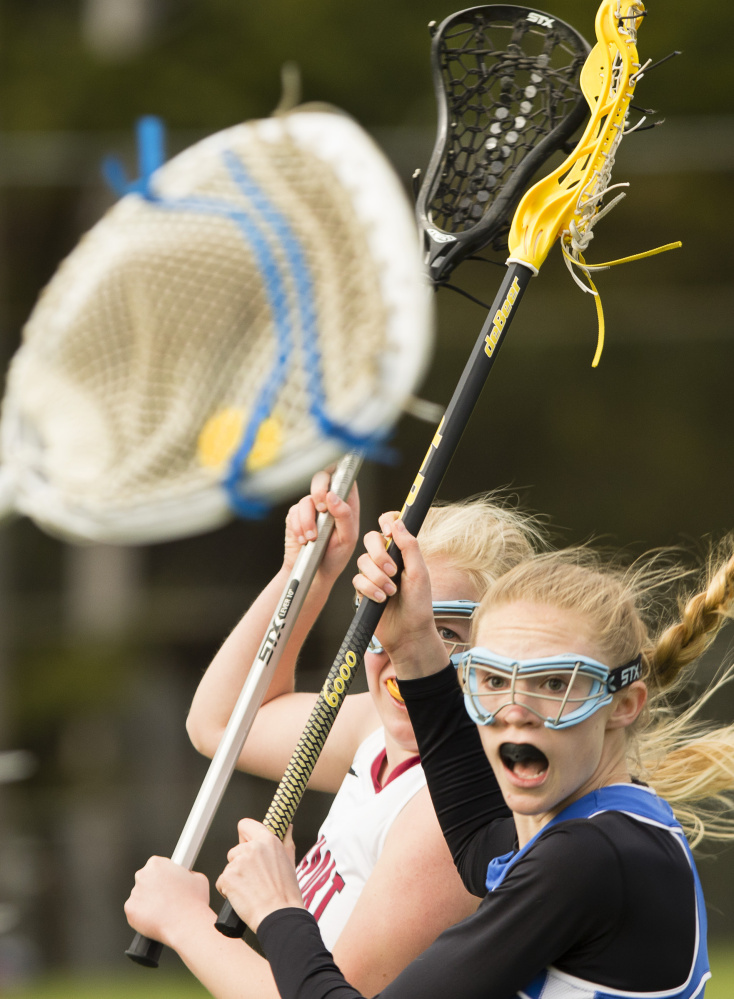 Morse's Mae Winglass, right, watches as Freeport's Lindsay Cartmell winds up for a shot on goal in Monday's girls' lacrosse game at Freeport. Morse won 7-6 in overtime.