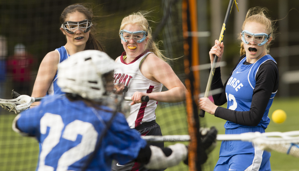 Morse goalie Zenaide McCarthy makes a save on a shot by Freeport's Lindsay Cartmell as teammates Isabella Monbouquette, left, and Mae Winglass watch in Monday's girls' lacrosse game at Freeport.