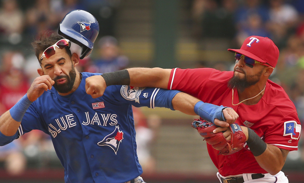 Rangers second baseman Rougned Odor punches Jose Bautista of the Blue Jays after Bautista slid hard into second Sunday. Odor was suspended eight games and Bautista one.