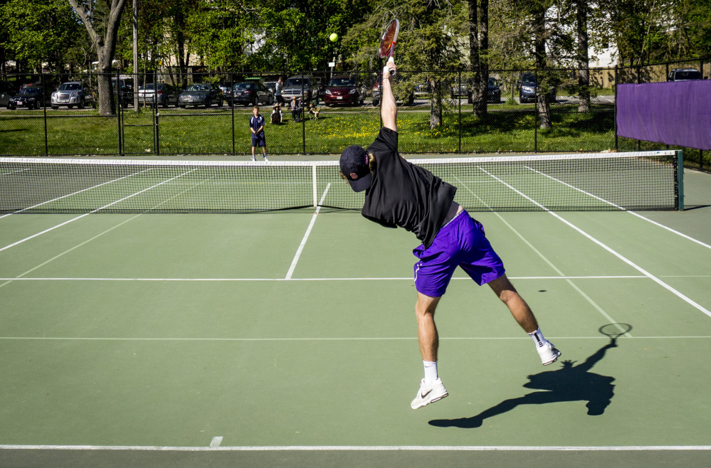 Will Weeks of Deering serves to Quinn Clarke of Portland during their boys' tennis match Wednesday at Deering High. Clarke won the match 6-3, 6-4 but Deering improved to 7-2 as a team with a 3-2 victory. Portland is 5-4.