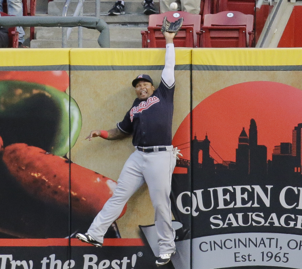 Cleveland center fielder Marlon Byrd hits the wall as he just misses a solo homer by the Reds' Jay Bruce in the Indians' 8-7 win Wednesday at Cincinnati.