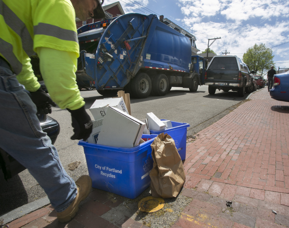 Recycling is picked up Thursday on Deering Avenue in Portland. Crews use different trucks to collect trash and recyclables and aren't allowed to mix the two, except when authorized because of unsafe road conditions.
