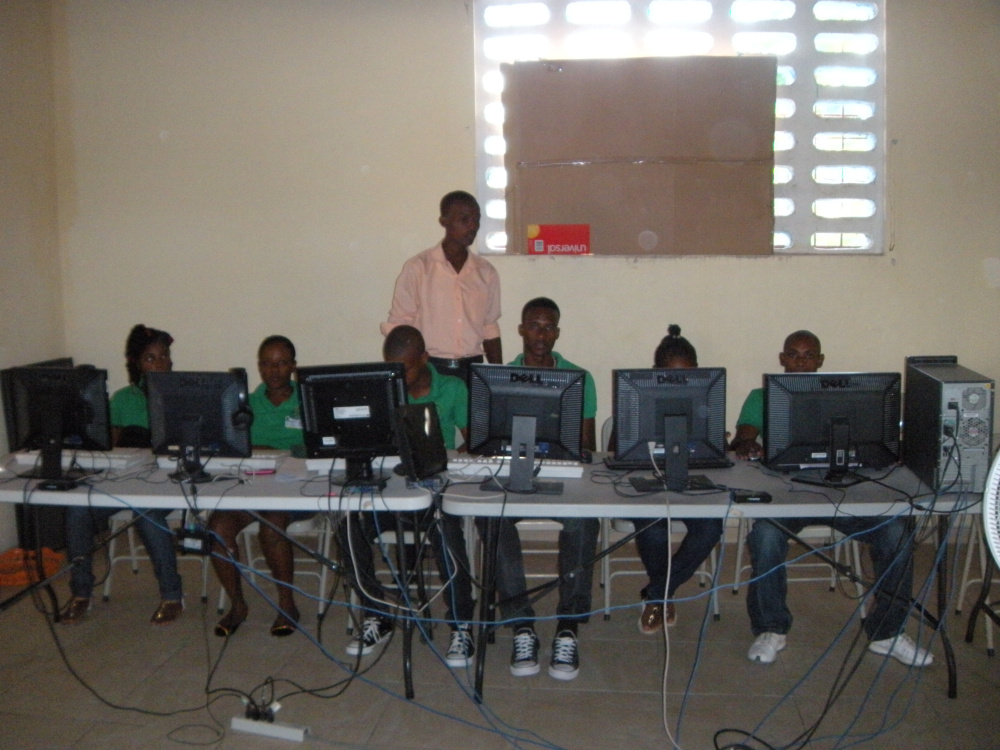 Photo courtesy of Jeanne Otis
Teacher Yves-Marie Laurent works with students in the St. Patrick computer lab in January.