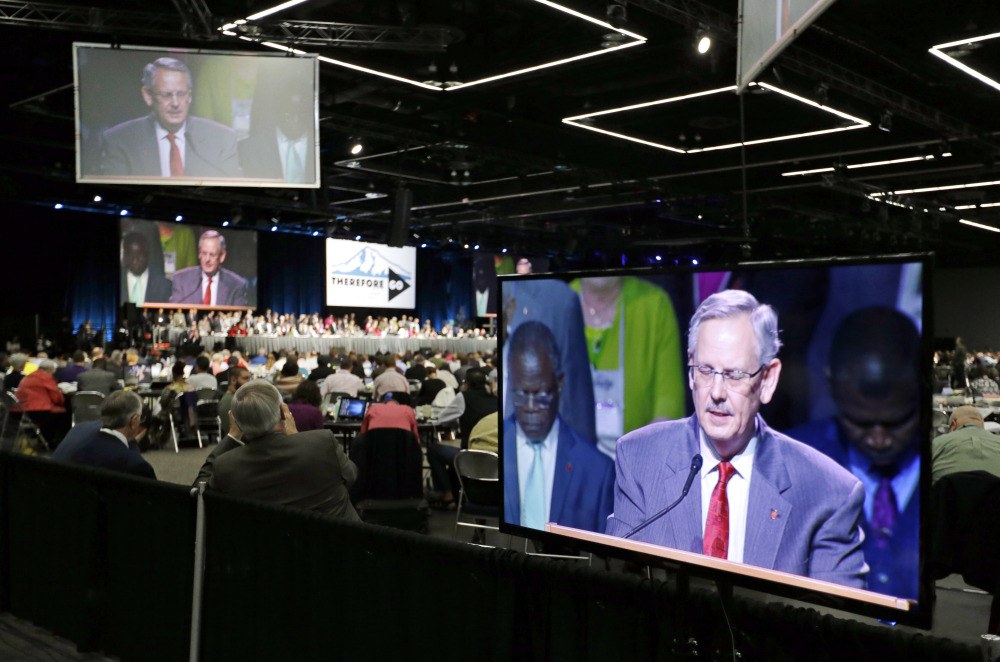 Methodist Council of Bishops President Bishop Bruce Ough is visible on multiple screens as he leads the room in prayer in Portland, Ore., Wednesday, May 18, 2016. The United Methodist Church, the nation's largest mainline Protestant denomination, is holding its once-every-four-years meeting here. It is facing a bitter fight over whether they should lift the church ban on same-sex marriage. (AP Photo/Don Ryan)