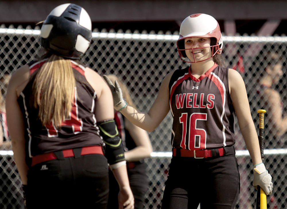 Sara Ring of Wells, left, is welcomed by teammate Casi Haye after scoring Friday during a 14-0 victory at Freeport – a game that ended after five innings. Wells improved its record to 8-5 and Freeport dropped to 3-10.