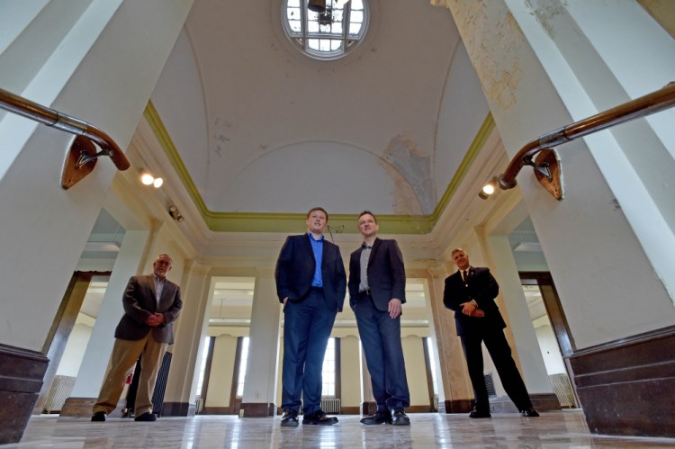 Alex Jason, left center, and his father, Bill Jason, right center, of Winslow stand in the former Carnegie Library on the Good Will-Hinckley campus in Fairfield, with Rob Moody, interim Good Will-Hinkley president, far left, and Sen. Scott Cyrway, R-Benton. The Jasons are renovating the building to create the Maine Technology Museum, which will house, among other things, Alex's vintage Apple computer collection.