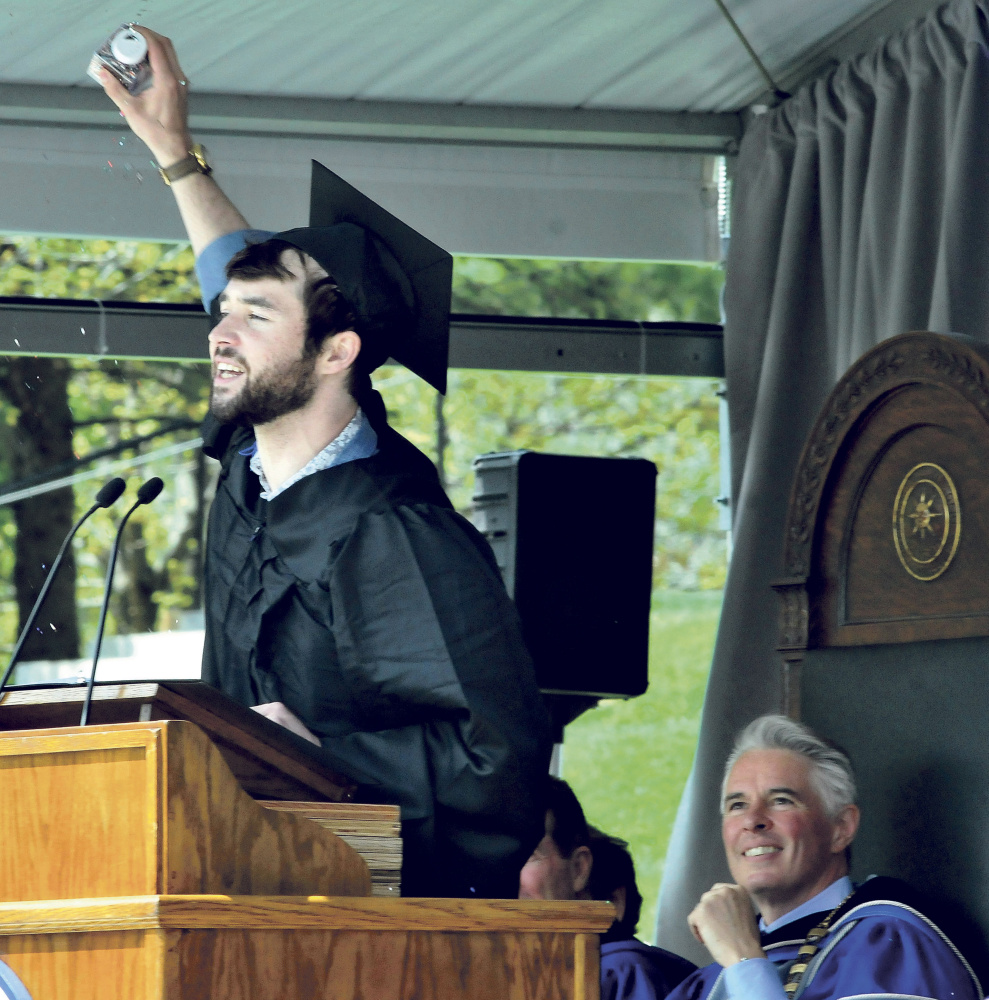 Colby College senior class speaker Brendan Leonard gestures during his address to fellow graduates at the college commencement in Waterville on Sunday. At right is college president David Greene.