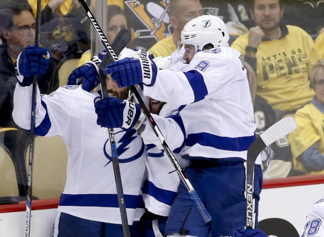Tampa Bay's Tyler Johnson, right, celebrates with Jason Garrison, left, and Nikita Kucherov after Johnson was credited with the goal that beat the Penguins, 4-3.
