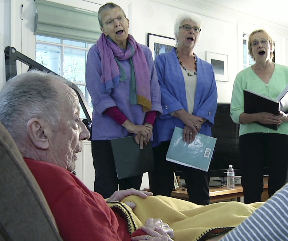 In a still image taken from video, members of the choir JourneySongs sing for Norman Doelling at his home in Newton, Mass. "It was very charming. I have a great deal of appreciation. It was very nice of them to come and sing to an old man," said Doelling, 85, who recently had a stroke.