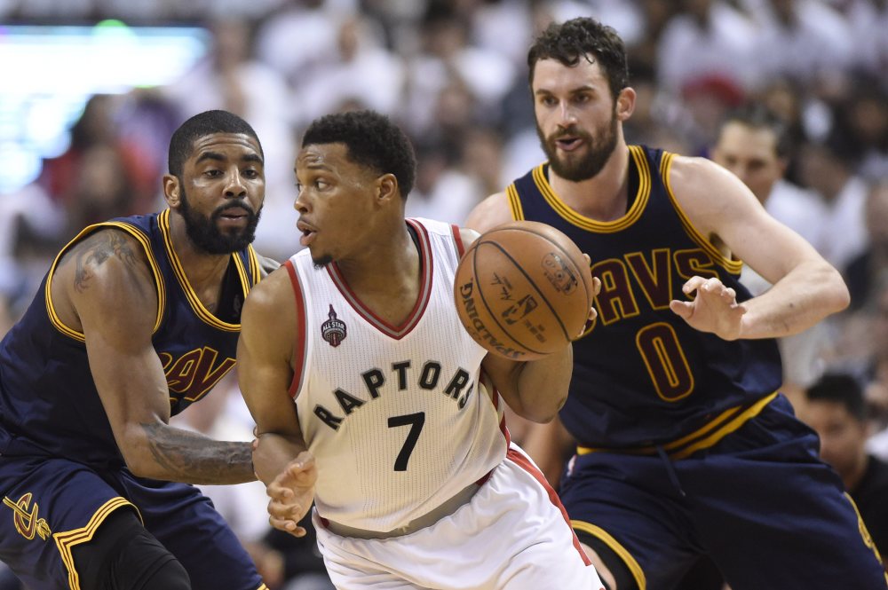 Toronto's Kyle Lowry controls the ball as Cavaliers forward Kevin Love, 0, and guard Kyrie Irving defend during the second half of Monday's Game 4 of the Eastern Conference finals at Toronto.