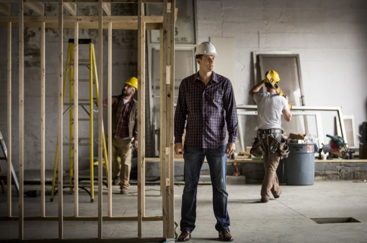 Nik Caner-Medley monitors construction at a co-working, meeting and event space called Cloudport that is due to open in July at 59 Federal St. in Portland. "I want to be smart with my money and invest it in my community," he said.