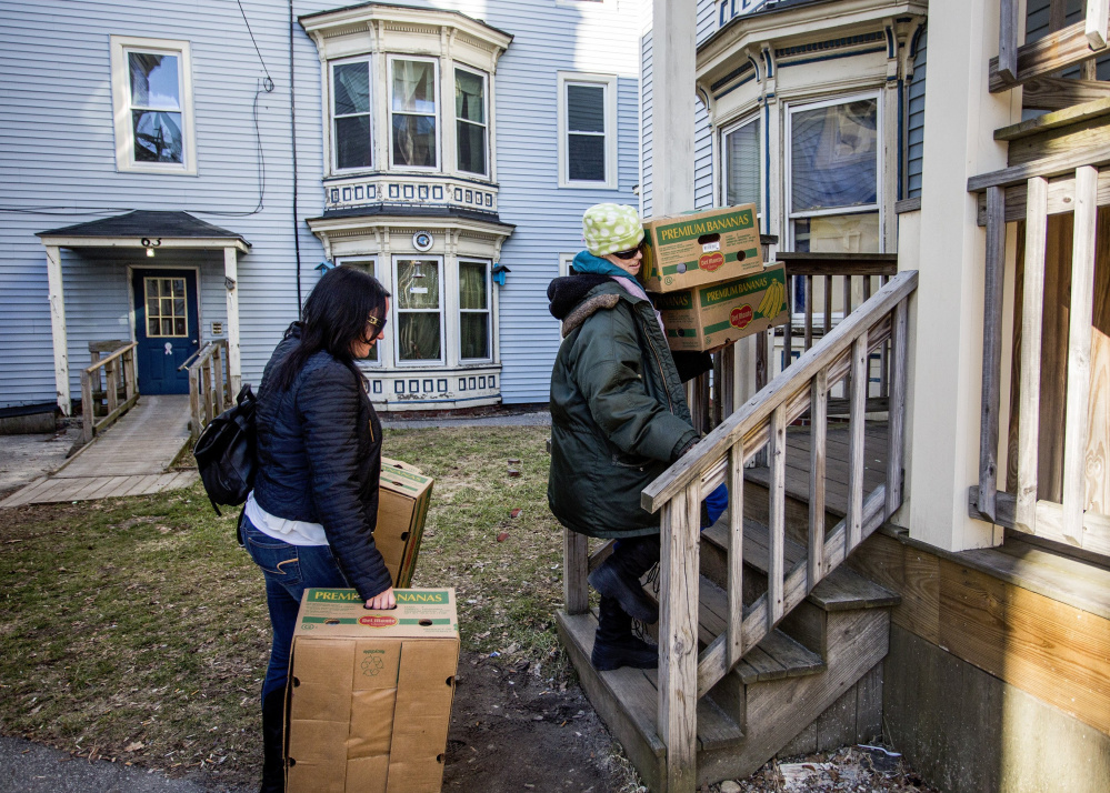 Chrissy Whitlock, left, helps Anna Teague move up to her apartment on Grant Street in February. Teague is one of many residents who have been evicted because of a building being sold and then renovated.