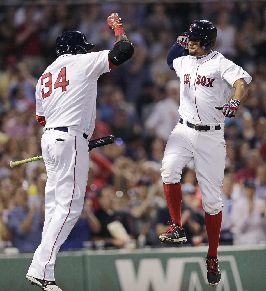 Boston's Xander Bogaerts, right, leaps as he celebrates his solo home run with David Ortiz off Colorado Rockies starting pitcher Chad Bettis in the fourth inning Wednesday night in Boston.