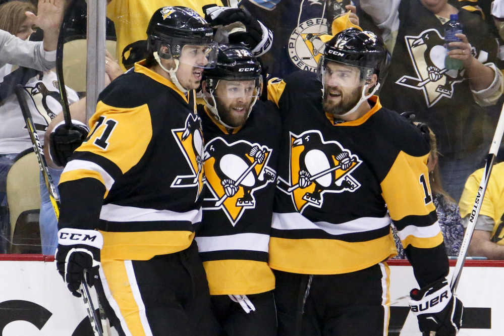 Bryan Rust of the Penguins, center is congratulated by Evgeni Malkin, left, and Ben Lovejoy after scoring his first goal Thursday night in Game 7 of the Eastern Conference finals against Tampa Bay.