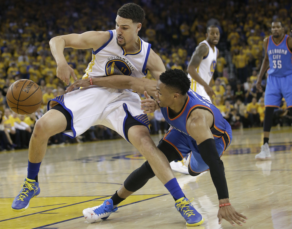 Warriors guard Klay Thompson, left, and Oklahoma City's Russell Westbrook reach for a loose ball in the first half of Game 5 of the Western Conference finals Thursday night in Oakland, Calif.