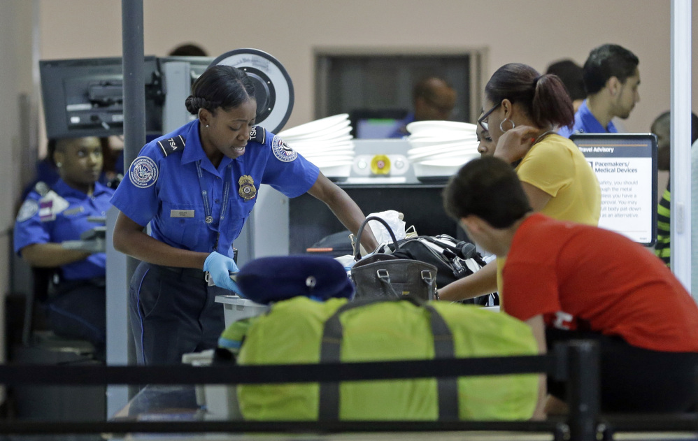 A Transportation Security Administration officer checks travelers luggage to be screened by an x-ray machine at a checkpoint at Fort Lauderdale-Hollywood International Airport, Friday, May 27, 2016, in Fort Lauderdale, Fla. Memorial Day weekend, the unofficial start of summer vacations for many and a busy travel period, serves as a crucial test for the TSA. (AP Photo/Alan Diaz)