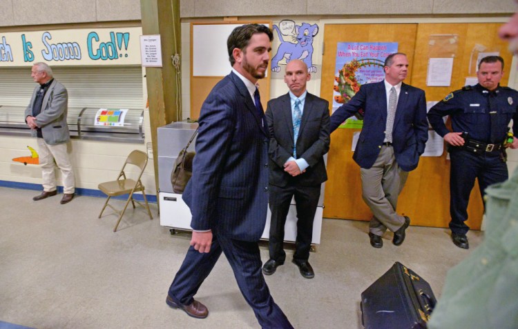 Don Reiter, Waterville Senior High School principal, leaves the school board during the first day of a hearing on charges he propositioned a student, as Detective Sgt. Bill Bonney, in back with arms crossed, looks on. Bonney, who led the criminal part of the investigation, has been named deputy chief of the department.