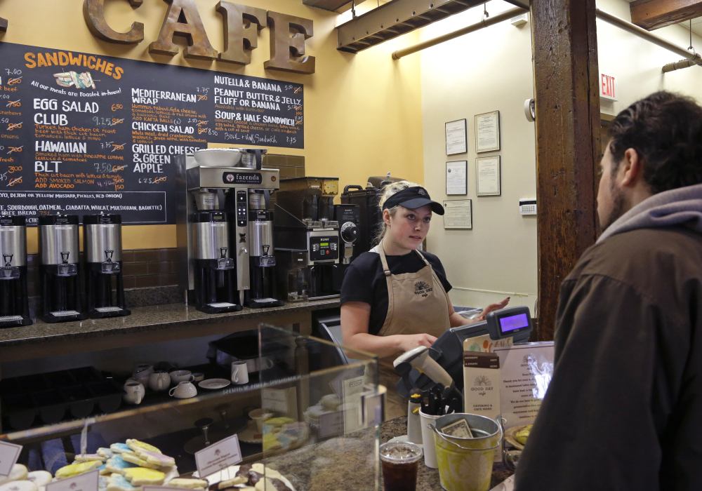 Kayla Mitchell serves a customer at Good Day Cafe in North Andover, Mass., on Friday. An initial assessment on U.S. growth has been revised upward.