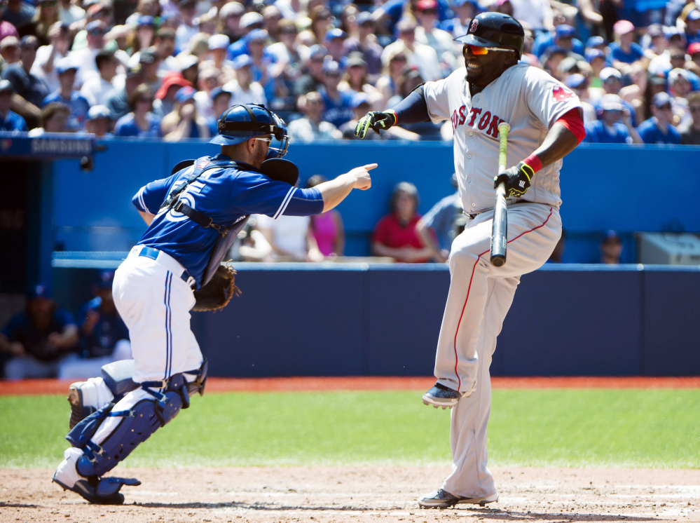 Boston Red Sox designated hitter David Ortiz reacts after apparently taking a foul ball to his leg as Toronto Blue Jays catcher Russell Martin (55) looks on during the fifth inning on Saturday.