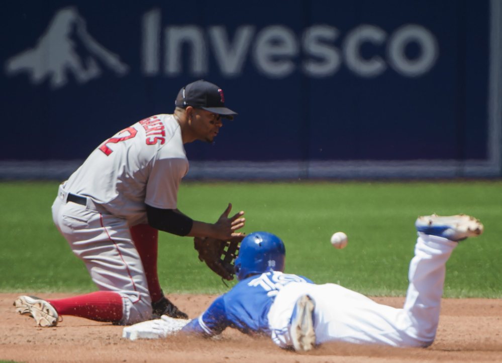 Toronto second baseman Darwin Barney slides safe past Boston shortstop Xander Bogaerts after hitting a double in the third inning of Saturday's game in Toronto.