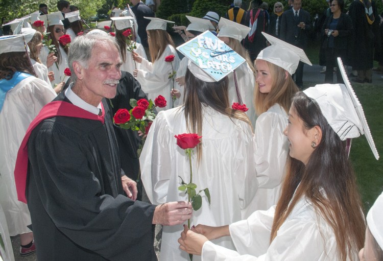Head of School Pat "Mr. Mac" McInerney hands out roses Saturday to female members of the class of 2016 in front of Bearce Hall before the graduation ceremony at Kents Hill School in Readfield.