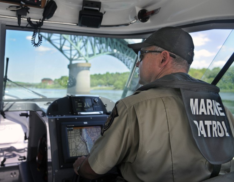 Marine Patrol Officer Clint Thompson patrols the Kennebec River on Tuesday beneath Memorial Bridge in Augusta. Officers from the agency that protects tidal water are checking boaters for safety equipment.