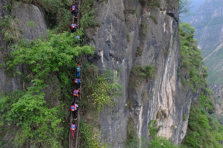 Children climb on a cliff on their way home from school in  Sichuan province. 
