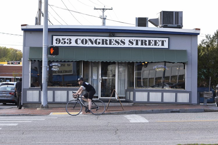 A cyclist passes 953 Congress Street which will soon reopen as Salty Sally's Bar & Grille.
