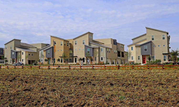 These townhomes – part of The Cannery development in Davis, Calif. – are built next to the fields of a small, urban farm that is a centerpiece of the community. The Associated Press