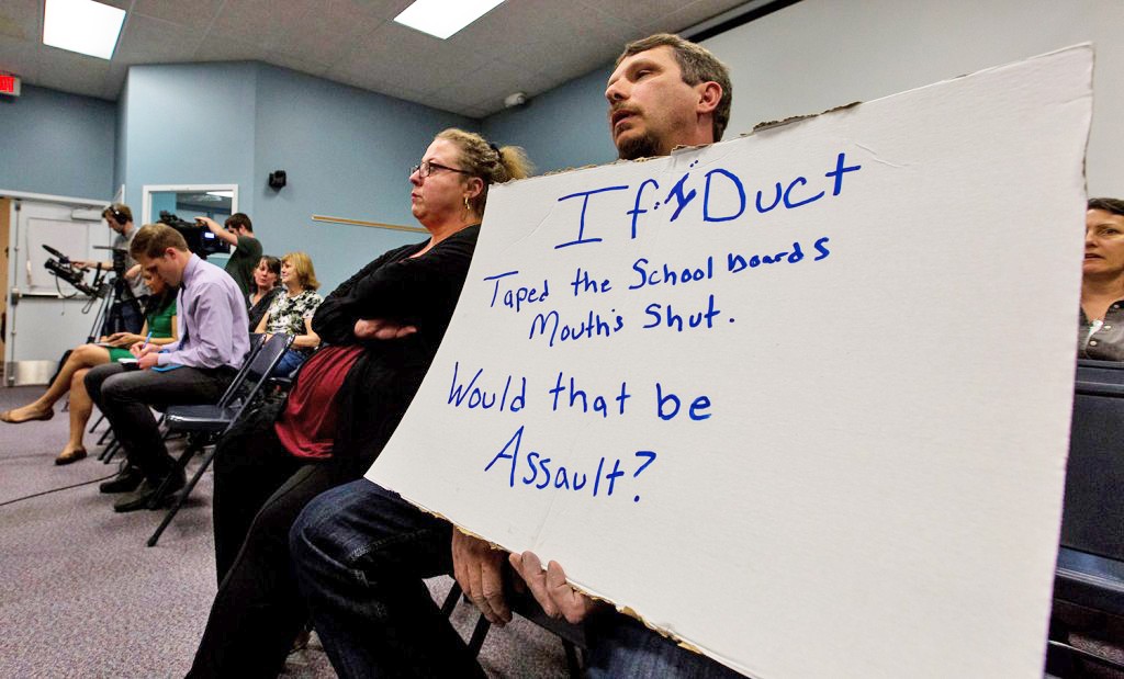 Richard Bourgeois-Lang of Buxton holds a sign protesting the SAD 6 board's handling of the controversy surrounding Superintendent Frank Sherburne. Bourgeois-Lang and his wife, Melissa Bourgeois-Lang, left, created an outburst at the end of the meeting, after it was clear that Sherburne had not been fired. Richard Bourgeois-Lang slammed his fists on the table where the board sat, saying, "You are not protecting our kids, you all need to go."