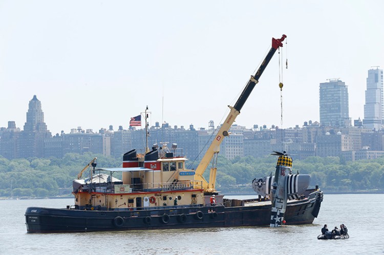 Officials remove the World War II vintage P-47 Thunderbolt out of the Hudson River a day after it crashed.