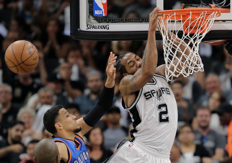 San Antonio's Kawhi Leonard had his dunk attempt blocked by Oklahoma City's Andre Roberson, left, during the Spurs' win Tuesday night.   The Associated Press