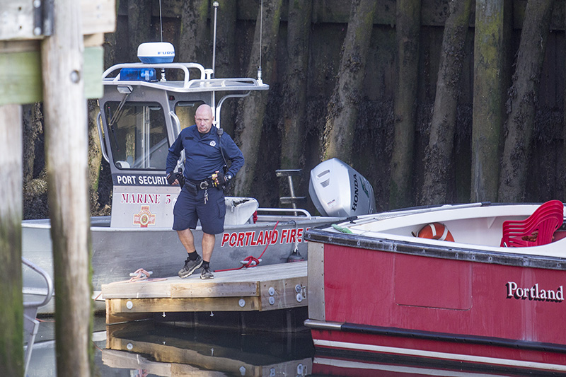 A police officer by the Casco Bay Ferry Terminal where police had put crime scene tape up around the area where the Portland Fire Department's boat is docked.