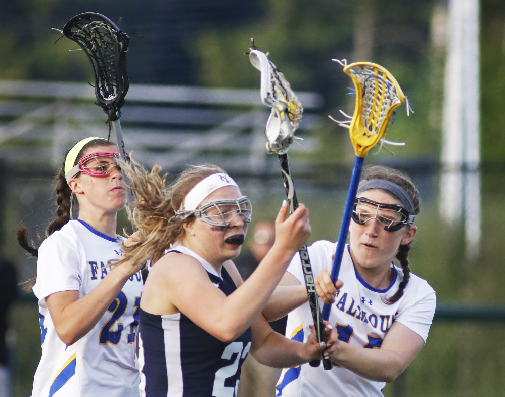 Yarmouth's Meredith Lane pushes forward past pressure of Falmouth's, left, Sydney Bell and Gabby Farrell in first half of Wednesday's girls' lacrosse game. Falmouth won, 14-7.