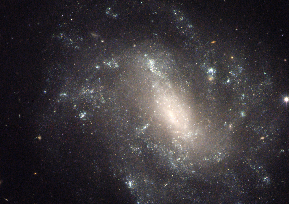 NASA image shows a barred spiral galaxy 130 million light-years away, one of the measurements that astronomers used to come up with a faster rate of expansion of the universe.