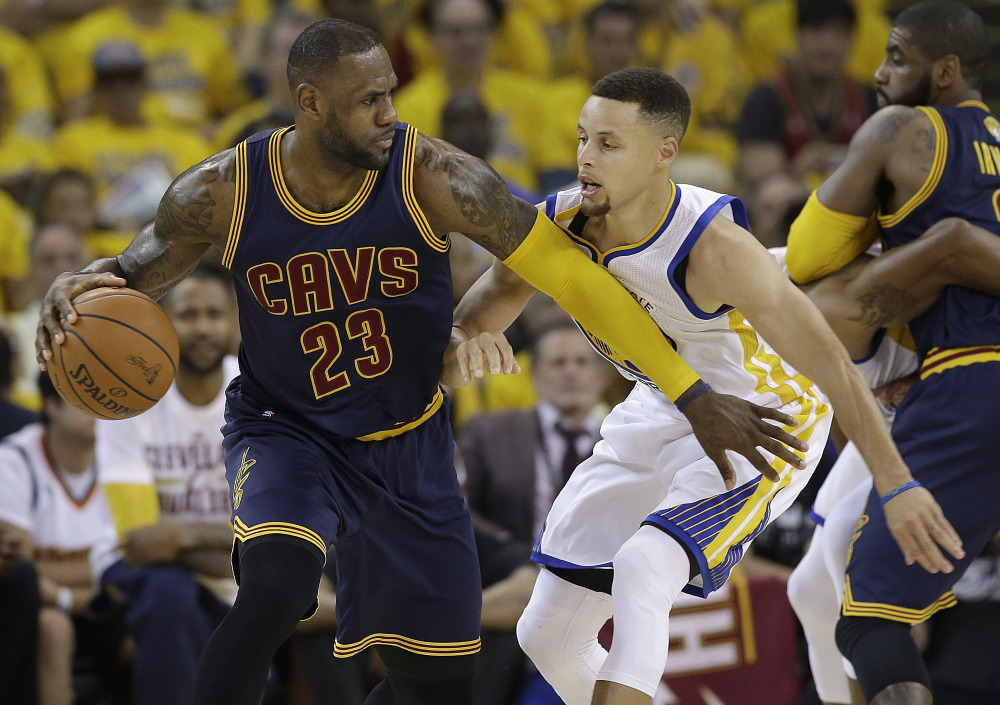 LeBron James dribbles against Stephen Curry in the first half of Game 1 of the NBA Finals on Thursday night, as the two superstars began their rematch of last year's finals.
