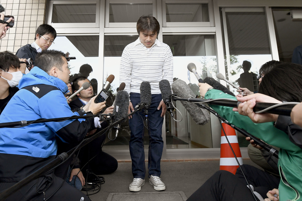 Takayuki Tanooka, father of the 7-year-old Japanese boy who went missing nearly a week ago, bows in front of media after his son was found, in Hakodate, Hokkaido, on Friday.