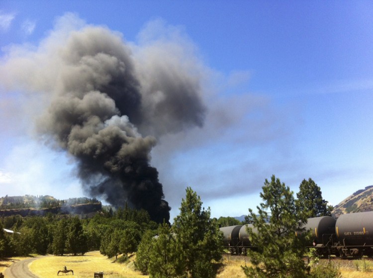 A train towing cars full of oil sends up a plume of smoke after derailing Friday near Mosier, Ore., near the scenic Columbia River Gorge. The accident happened just after noon about 70 miles east of Portland.