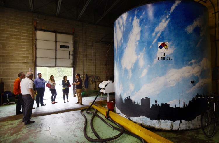 Alex Pike, right, of Maine Standard Biofuels leads a tour of the plant Friday during the Plants to Products Forum. To the right is a tank with the company's finished product, biodiesel.