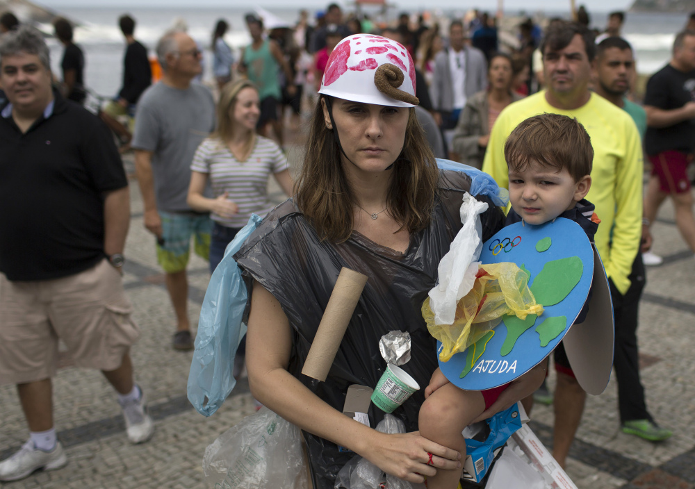 Renata Zacaro and her son Vicent, both wearing handmade costumes fashioned out of recycled trash, protest against inaction on pollution in Brazil on Saturday.