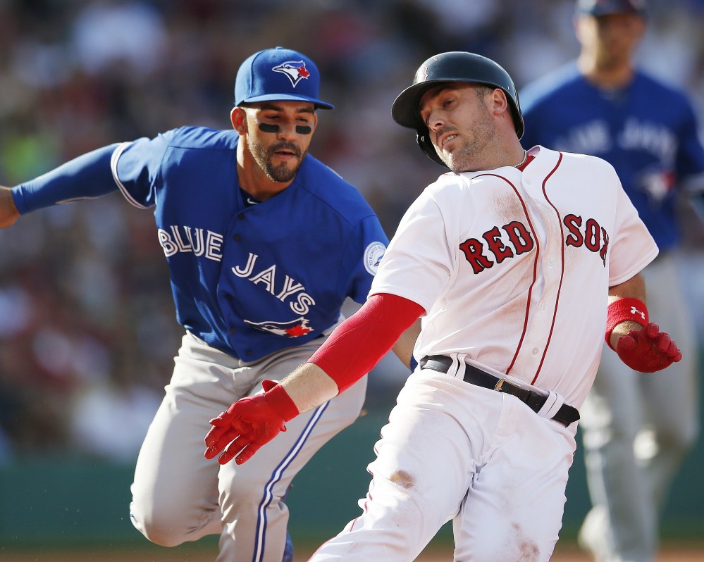 Blue Jays' Devon Travis tags Boston's Travis Shaw on a rundown at first base during the fifth inning Saturday at Fenway.