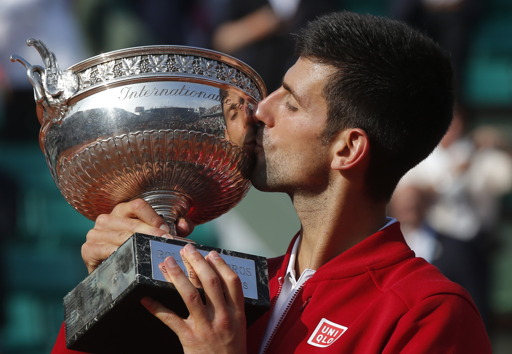 Serbia's Novak Djokovic kisses the trophy after winning the final of the French Open tennis tournament against Britain's Andy Murray at the Roland Garros stadium in Paris, France, Sunday, June 5, 2016.