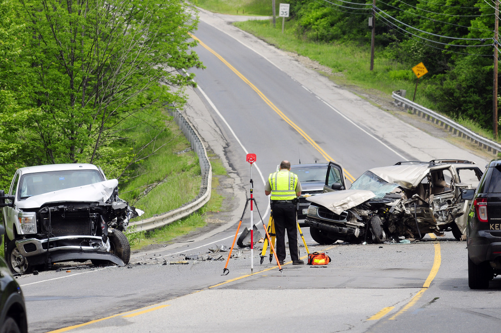 Officials work at the scene of a two-vehicle crash on Tuesday on Route 202 in Manchester near the Augusta line. A 22-year-old woman was killed.
