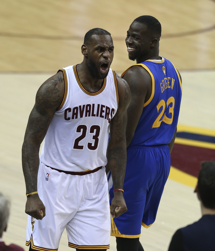 Cavaliers forward LeBron James, left, reacts as Warriors forward Draymond Green looks back during the first half of Game 3 of the NBA Finals Wednesday in Cleveland.