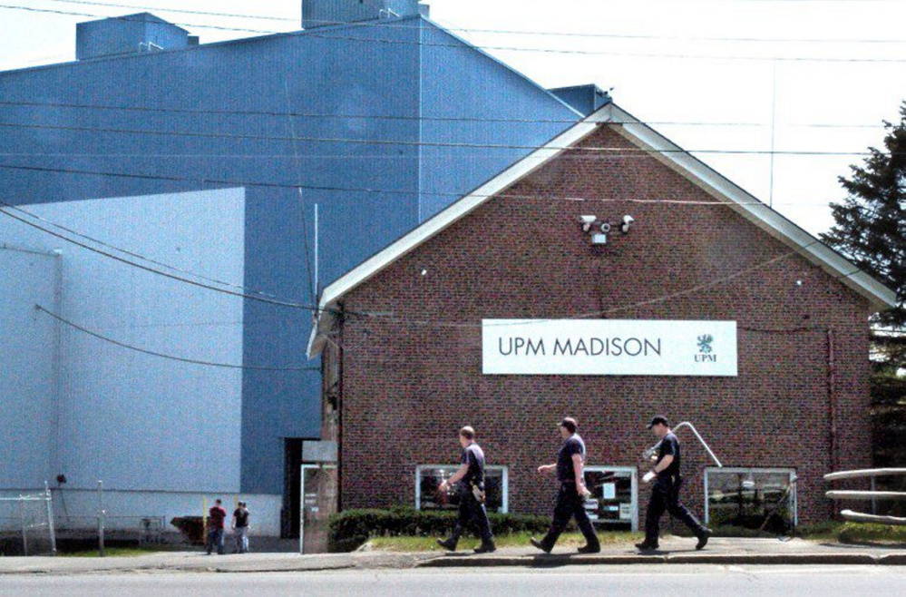 Workers carry tools into the Madison Paper Industries mill on May 23, the last day of production. The town recently was given a good credit rating even though the mill had closed.
