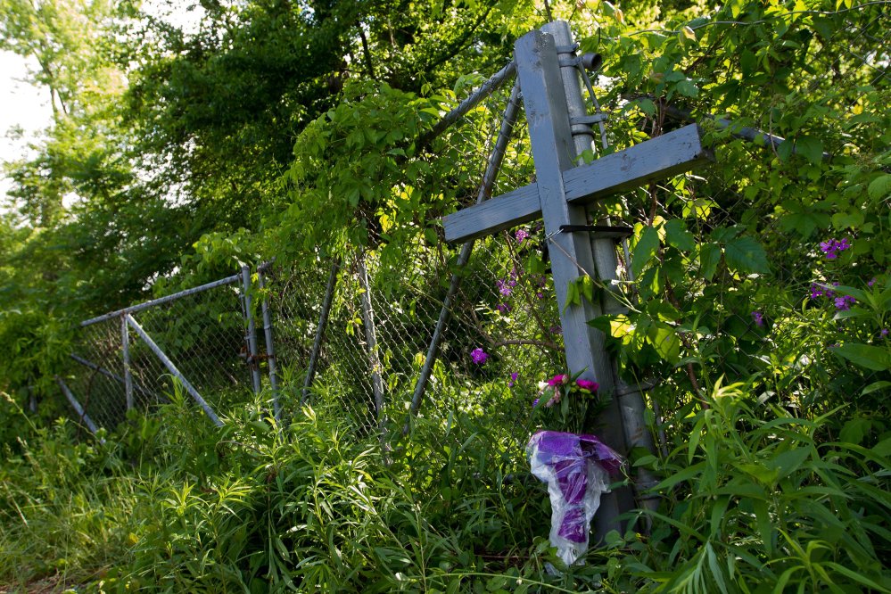 A cross and flowers form a memorial at the scene of Tuesday's fatal crash in Cooper Township, Mich.