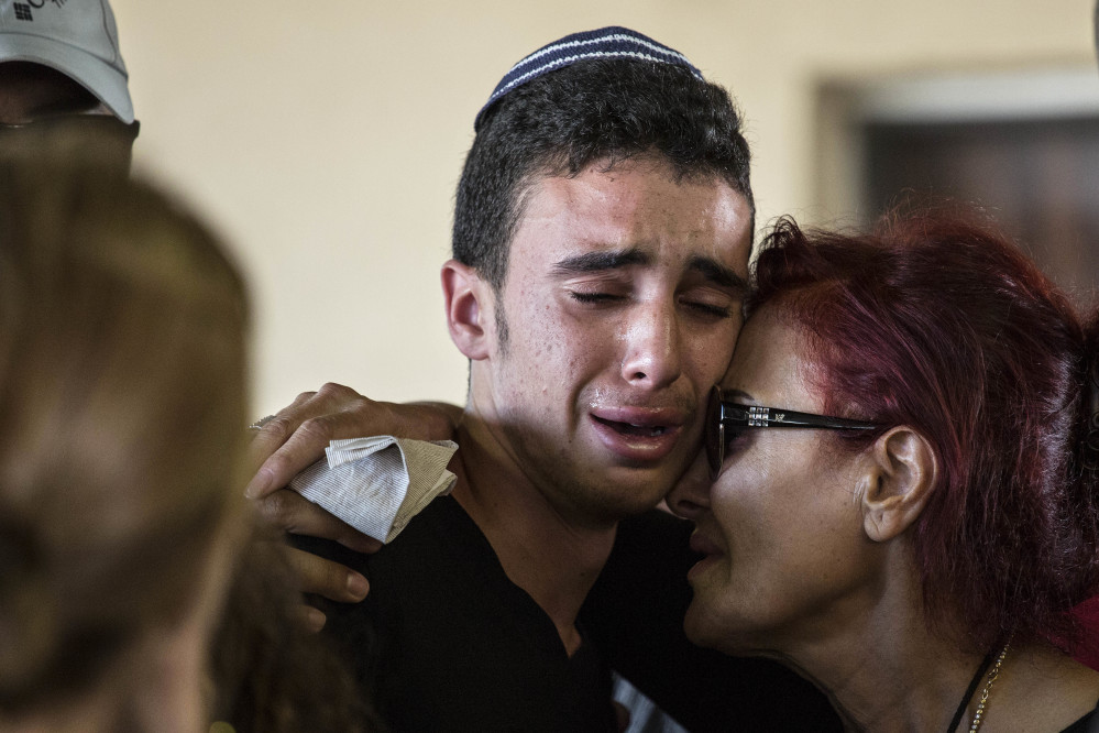 Israeli relatives mourn during the funeral of Ido Ben Arieh, 42, at the cemetery in Yavne, Israel, on Thursday. A shooting by two West Bank Palestinians killed four people.