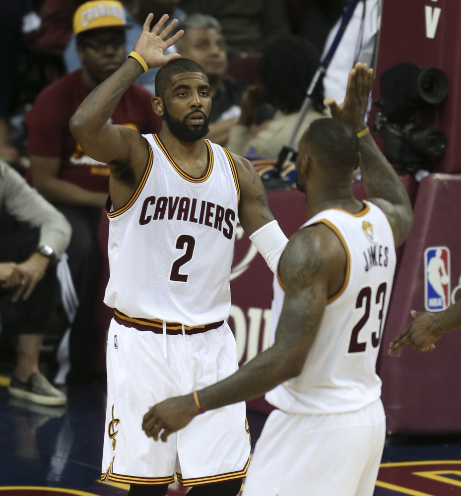 Kyrie Irving, left, and LeBron James of the Cavaliers celebrate their 120-90 win against the Warriors in Game 3 of the NBA Finals on Wednesday. The two stars promised to pick up the slack for ailing teammate Kevin Love, out with a concussion.